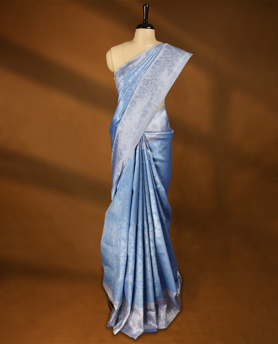 Pastel Blue coloured semi silk saree featuring a Silver coloured Zari design on the body, paired with a Baby Blue coloured border and matching blouse.