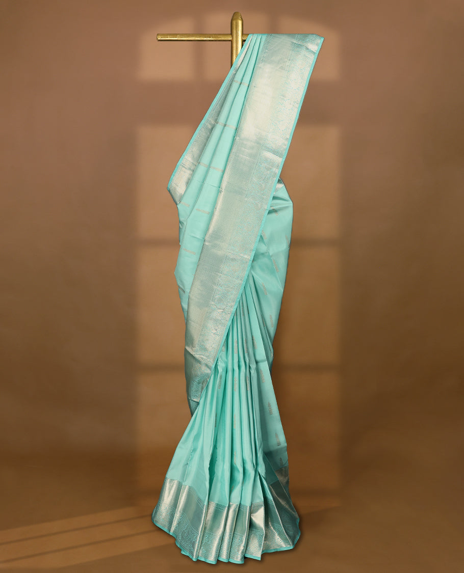 Light aqua Colour pure traditional Kancheepuram silk saree embellished with antique zari motifs on the body, gracefully complemented by a traditional peacock design border, and paired with a matching blouse.