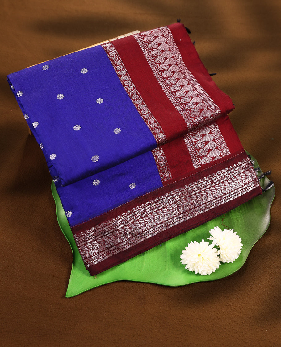 Blue colour mixed Kalyani cotton saree featuring Silver zari flower motifs throughout the body, paired with a Maroon colour traditional border and pallu, with matching blouse