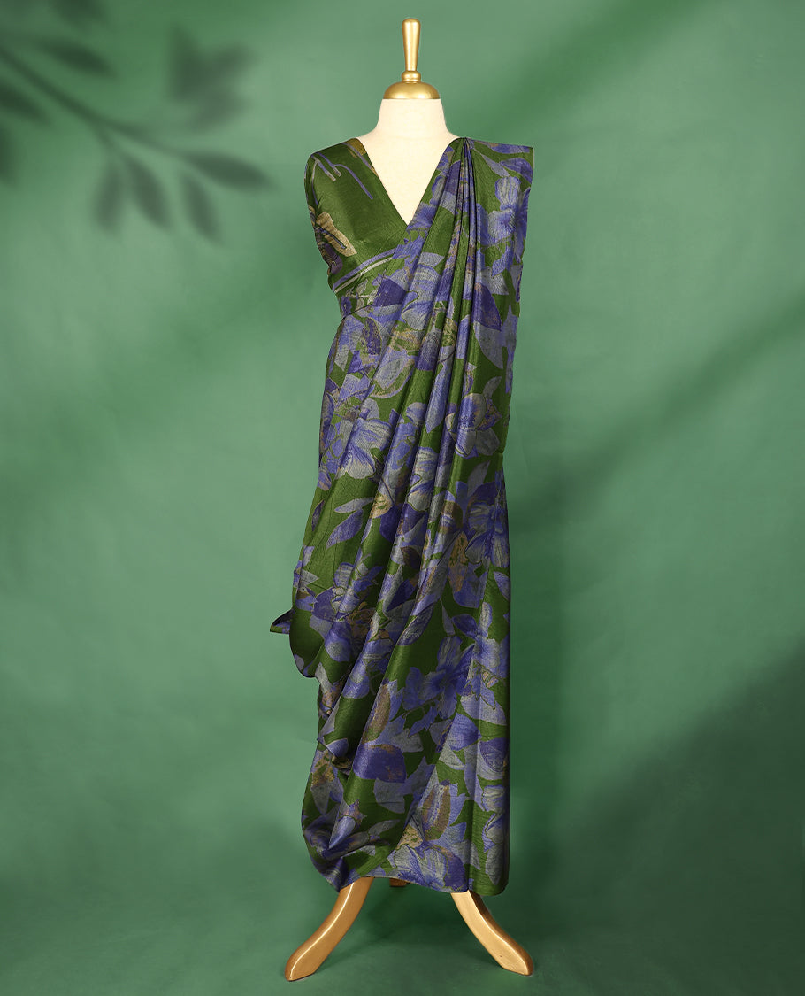 Deep olive green Colour Manipuri saree featuring oversized periwinkle blue and muted floral motifs, finished without a border, and paired with a matching blouse.