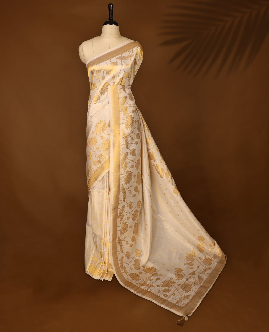 Elegant off white colour soft tissue Kerala saree with golden floral weaving and zari border, Lightweight and sheer, paired with a matching blouse & ideal for festive and traditional occasions.