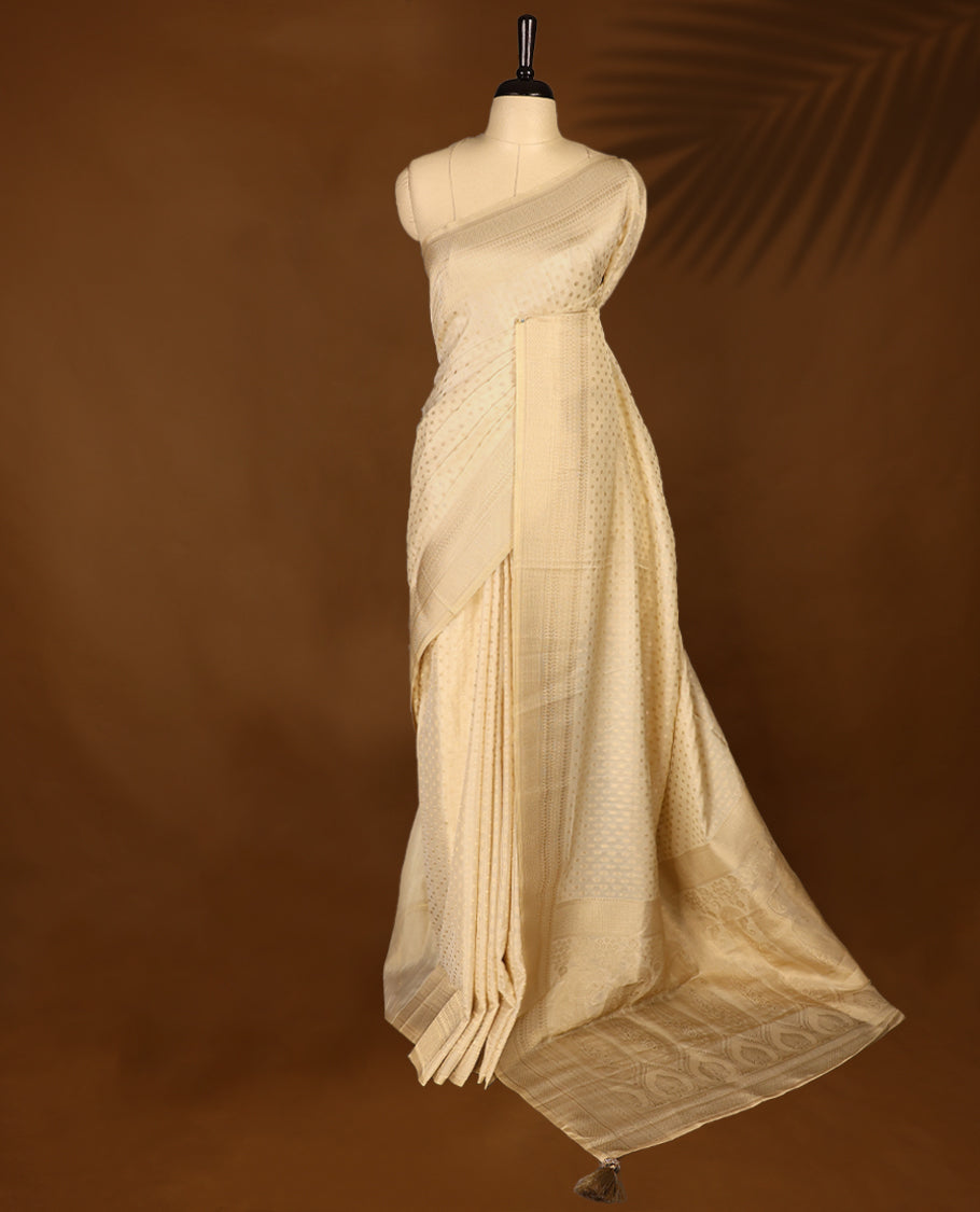 Off white colour georgette Kerala saree featuring intricate dotted woven patterns on the body, complemented by a subtly traditional border and pallu, paired with a matching blouse.
