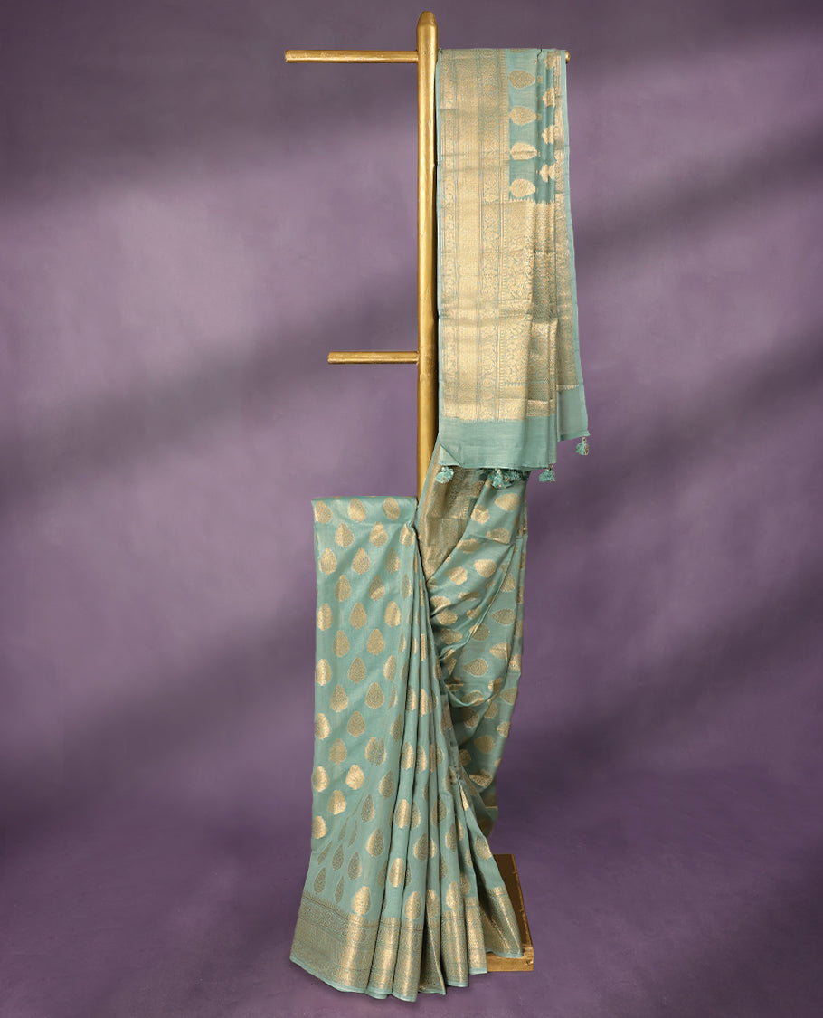 Light Aqua colour pure Banarasi Chanderi cotton, beautifully adorned with traditional antique zari Medium Butta designs across the body, completed with a hand-dyed colour, a traditional border, and a matching blouse.