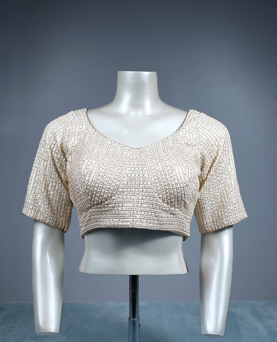 Champagne beige designer padded readymad blouse embellished with vertical sequin lines, featuring a sweetheart neckline and elbow length sleeves.