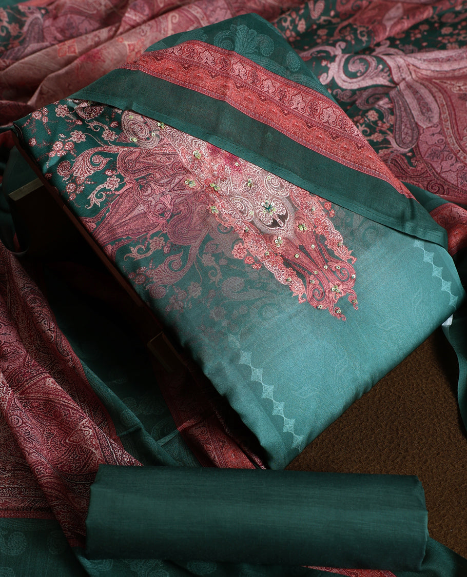 Dark green colour churidhar material featuring intricate embroidery with subtle paisley patterns, paired with a richly printed dupatta and plain bottom.