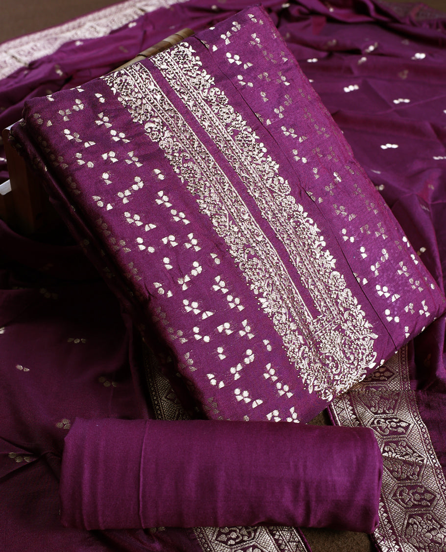 Grape colour churidhar material featuring golden zari woven motifs with an ornate traditional border, paired with a plain matching bottom and rich dupatta, perfect for weddings, festive occasions, and grand celebrations.