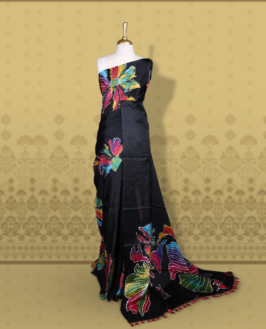 Black colour semi khadi silk saree adorned with yellow, green and magenta colour bold floral motifs across the body, designed without a border for a contemporary touch, and paired with a matching blouse.