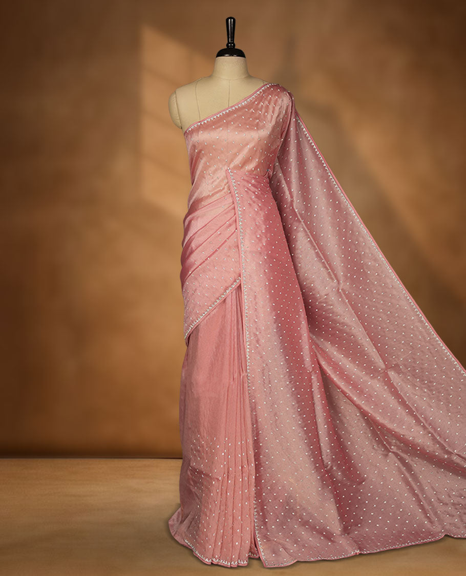Dusty rose colour net shimmer fancy saree adorned with scattered white stone buttas, paired with a delicate stone worked border and matching blouse.
