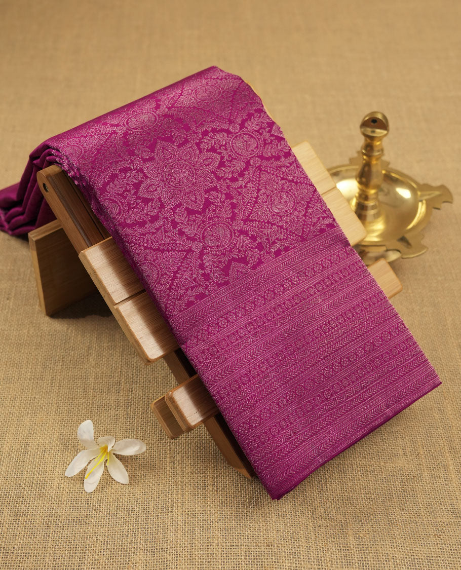 Magenta colour Kanchipuram pattern Manthrakodi saree adorned with antique copper zari floral creeper design featuring traditional peacock and elephant motifs, complemented by a rich zari jacquard border and blouse piece.