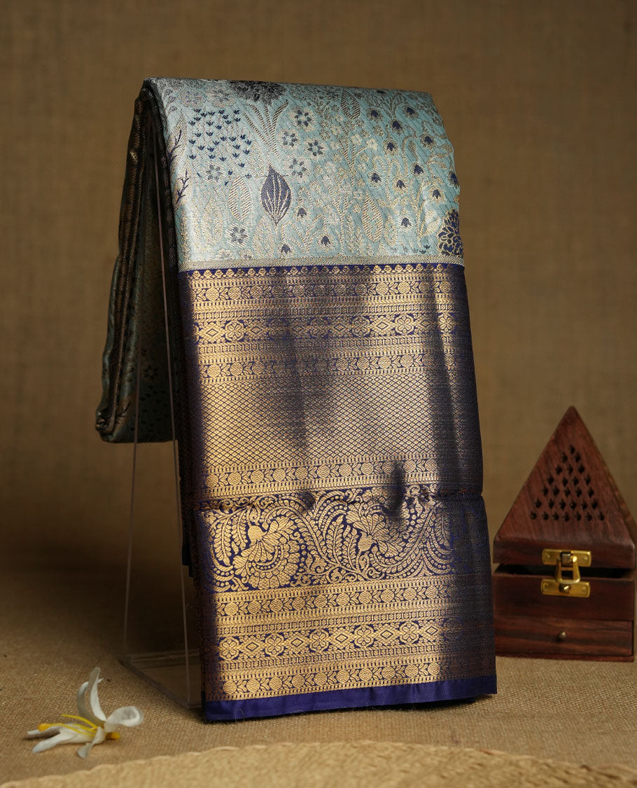 Aqua blue colour and Antique gold Zari Tissue Brocade Saree features intricate floral Motifs on body and navy blue colour border & pallu with traditional patterns paired with matching blouse