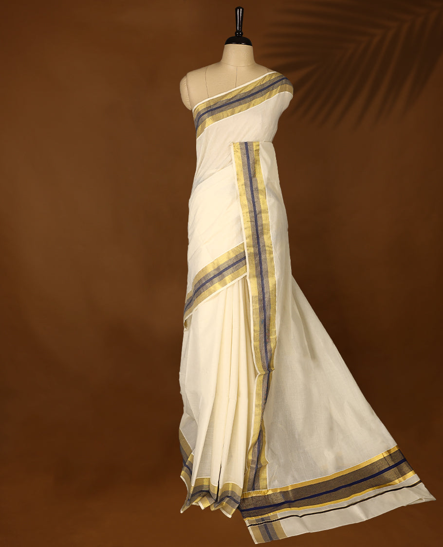 Elegant off white colour cotton Kerala saree featuring Plain body, Navy Blue colour & golden zari kasavu border offering a classic and graceful look, paired with a matching blouse.