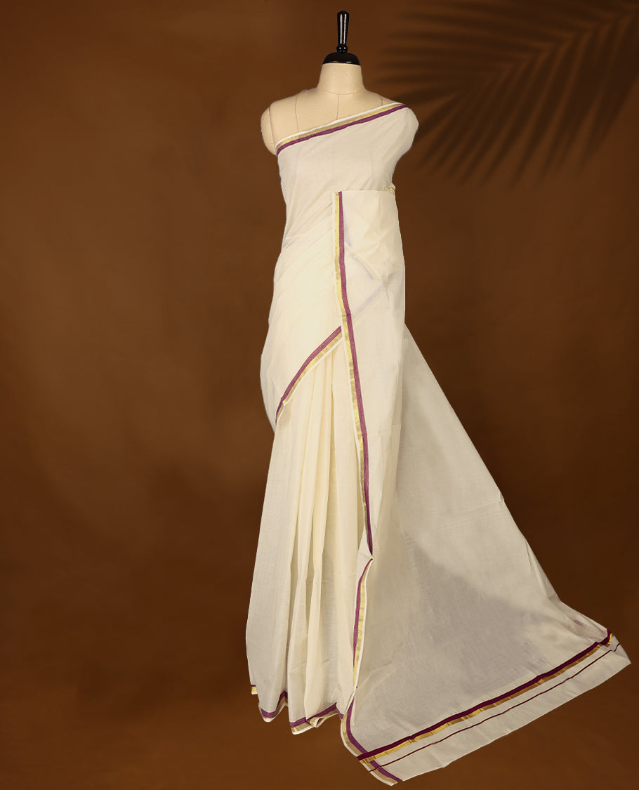 Elegant off white colour cotton Kerala saree featuring a plain body and traditional golden zari border with a hint of Grape purple, offering a classic and graceful look, paired with a matching blouse.