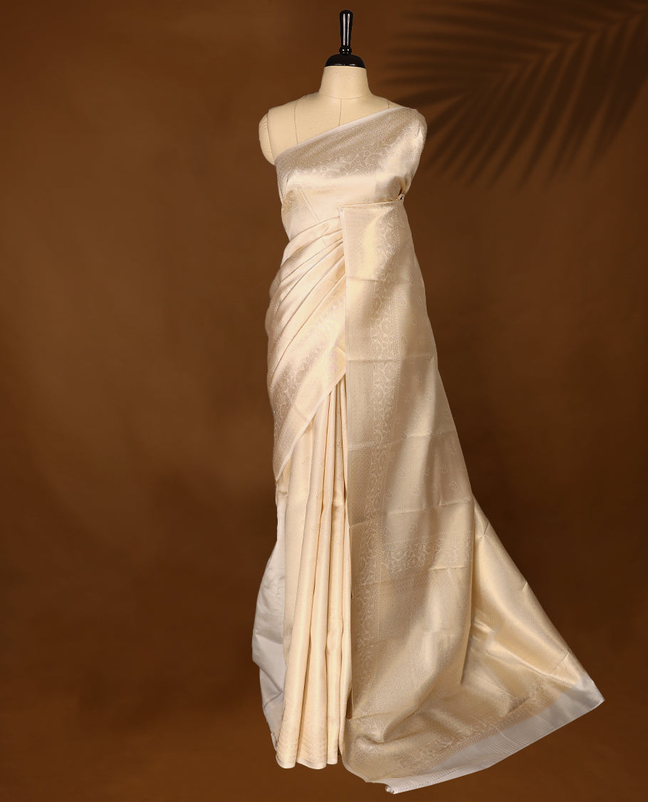 Muted gold Colour soft tissue Kerala saree featuring selfcolour flower motifs on body, Floral kodi designed border, paired with a matching blouse.
