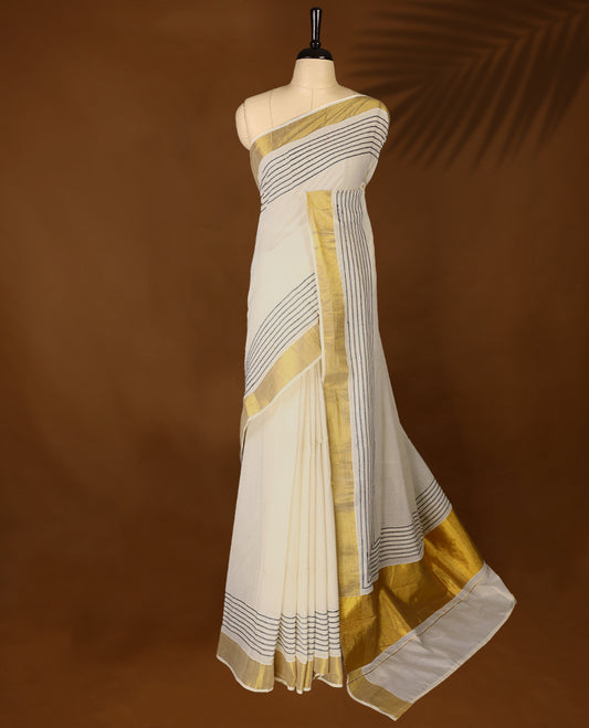 Elegant off white colour cotton Kerala saree featuring Blue colour Thread detailing on body, gold zari traditional kasavu border, Paired with matching blouse offering a classic and graceful look, paired with a matching blouse.