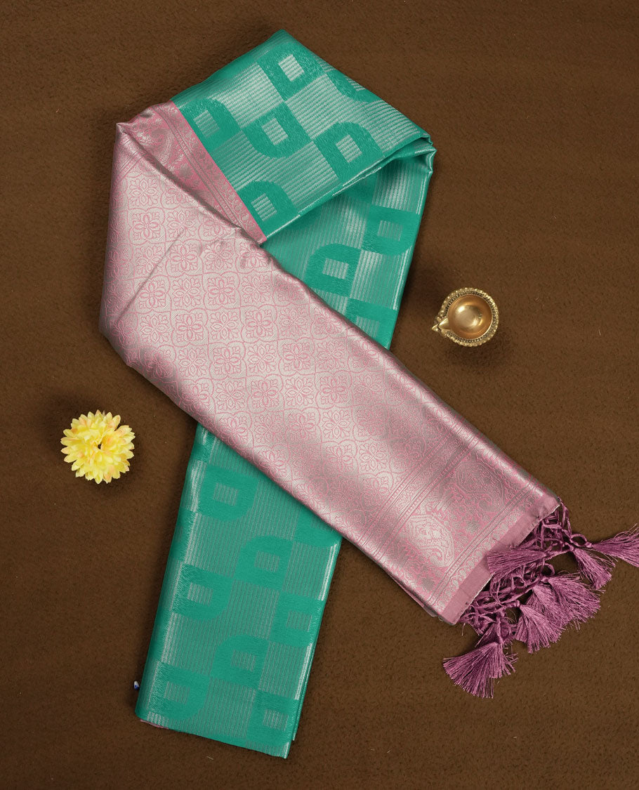 aqua green colour semi silk saree adorned with silver zari designs on the body, complemented by a contrasting pastel pink border and pallu, and paired with a matching blouse piece.