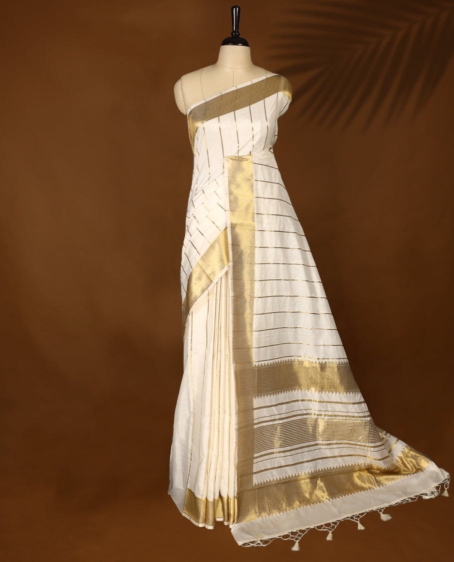Elegant white colour sotf Tussar Kerala saree featuring thin stripes on body, Gold kasavu border, Rich Pallu, Paired with matching blouse offering a classic and graceful look