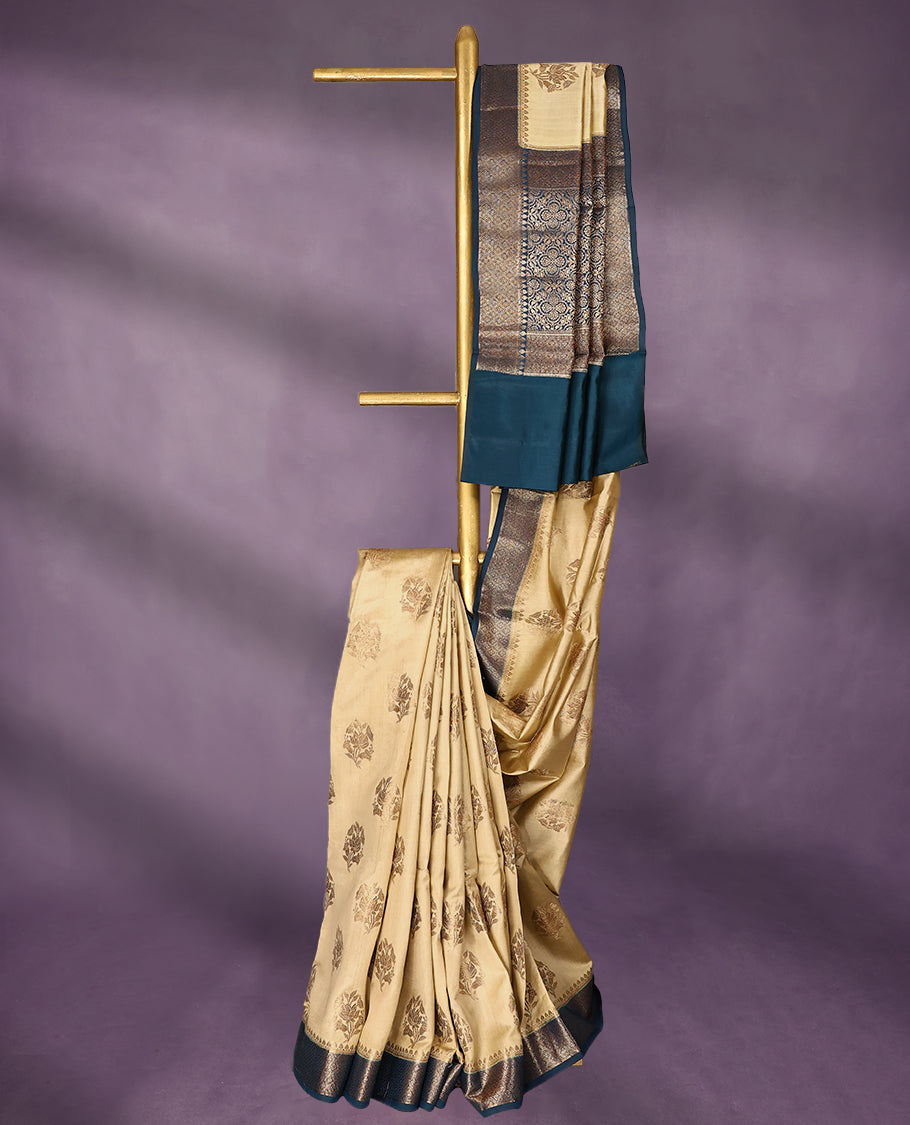 Beige Colour Pure Banaras Soft Silk Saree adorned with traditional antique zari motifs, paired with a hand dyed German Blue antique style border and a matching blouse.