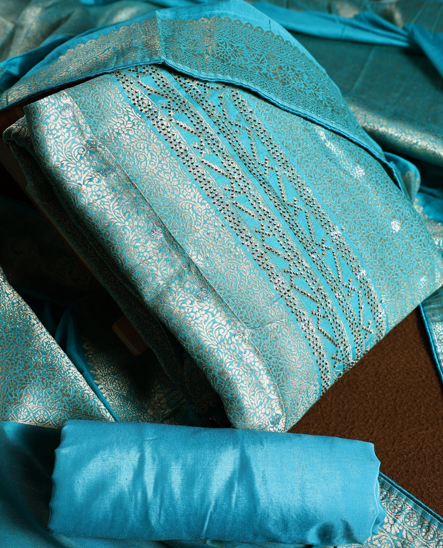 Turquoise blue colour churidhar material with elegant golden zari floral weaves and stone embellishments, paired with a plain matching bottom and dupatta.