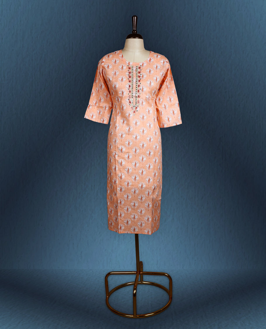 Peach colour kurti with all over white floral prints, featuring a round neckline adorned with vertical thread and mirror embroidery, and three quarter sleeves