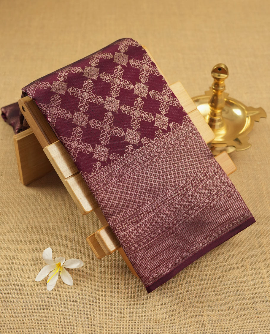 Dark wine colour Kanchipuram pattern Manthrakodi saree adorned with diamond antique gold zari jacquard on the body, highlighted by a rich geometrical pattern border and complemented with a self jacquard blouse piece.
