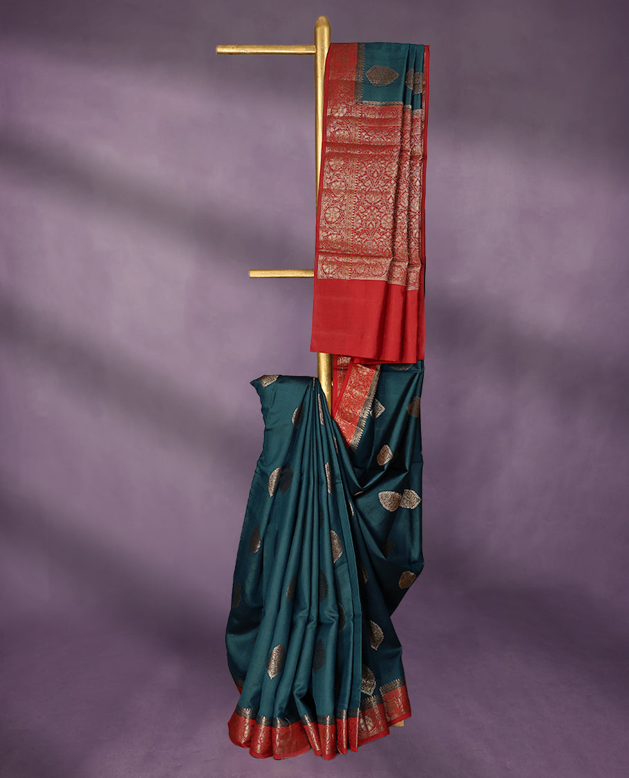 Greman Blue Colour Pure Banaras Soft Silk Saree adorned with traditional antique zari motifs, paired with a hand dyed Chilly Red antique style border and a matching blouse.