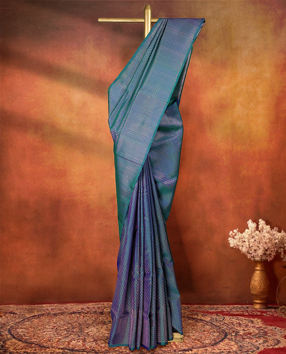 Peacock blue and green dual tone pure Mayuri silk saree featuring intricate gold Zari woven patterns across the body, highlighted with a rich geometric woven border, with matching blouse