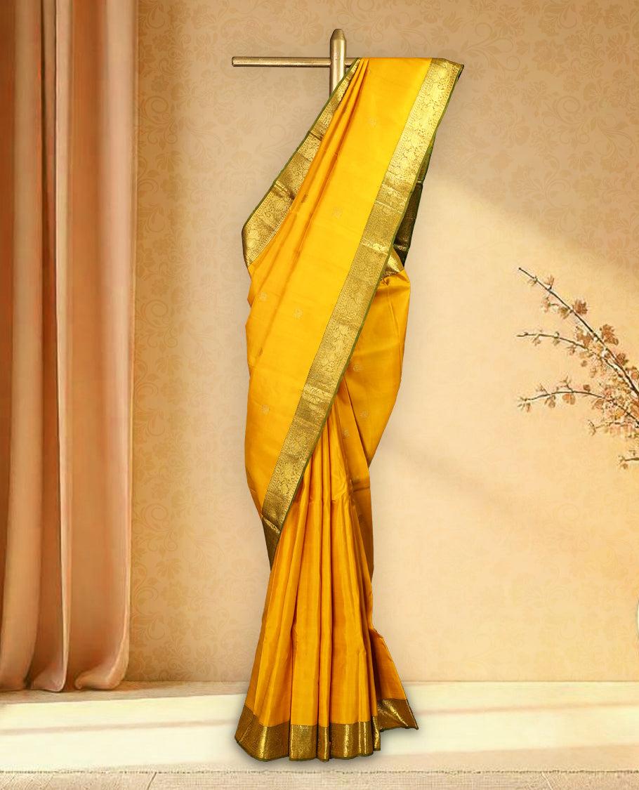 Mustard colour pure Kancheepuram saree with gold zari Mayoora chackra motifs on the body traditional contrast border with elephant and annam motifs grand pallu paired with matching blouse