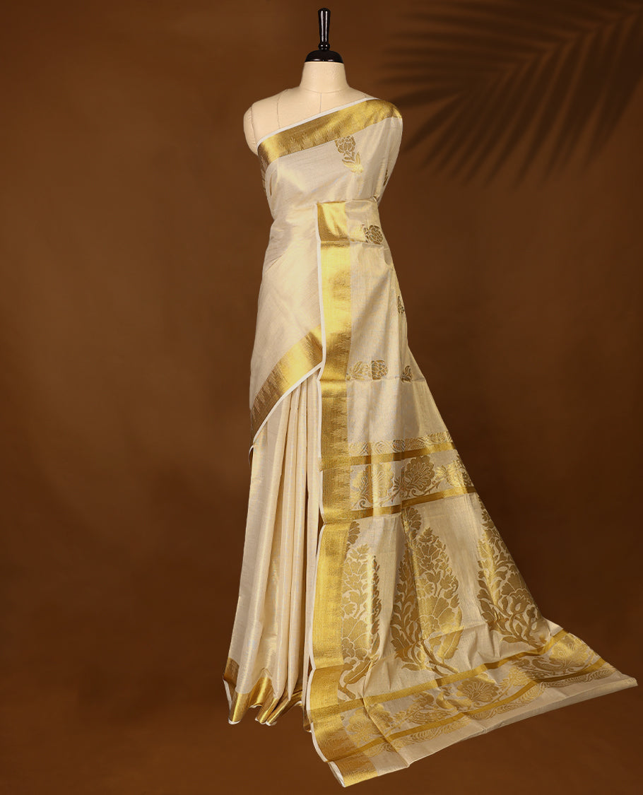 Elegant Light Gold colour Tissue Kerala saree featuring Flower Motifs on body, traditional golden zari kasavu border & Rich Pallu offering a classic and graceful look, paired with a matching blouse.