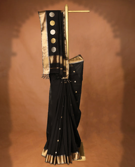 Pure Black colour Maheshwari Cotton saree featuring Antique Zari bindi Patterns across the entire body, complemented by a traditional Gold Zari border & Pallu, with a matching blouse.
