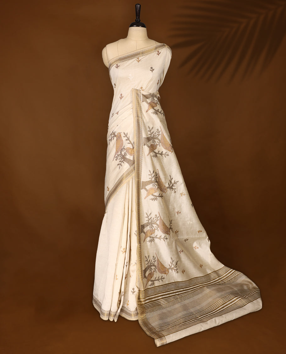 Soft Tussar saree in elegant off white shade, featuring intricate bird and branch motifs across the body, enhanced with a subtle grey golden woven border and pallu, paired with a matching blouse.