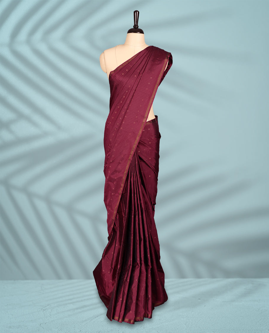 Maroon Red colour semi silk saree features a subtle checked body design with small woven motifs, a simple gold zari border, and comes with a matching blouse.