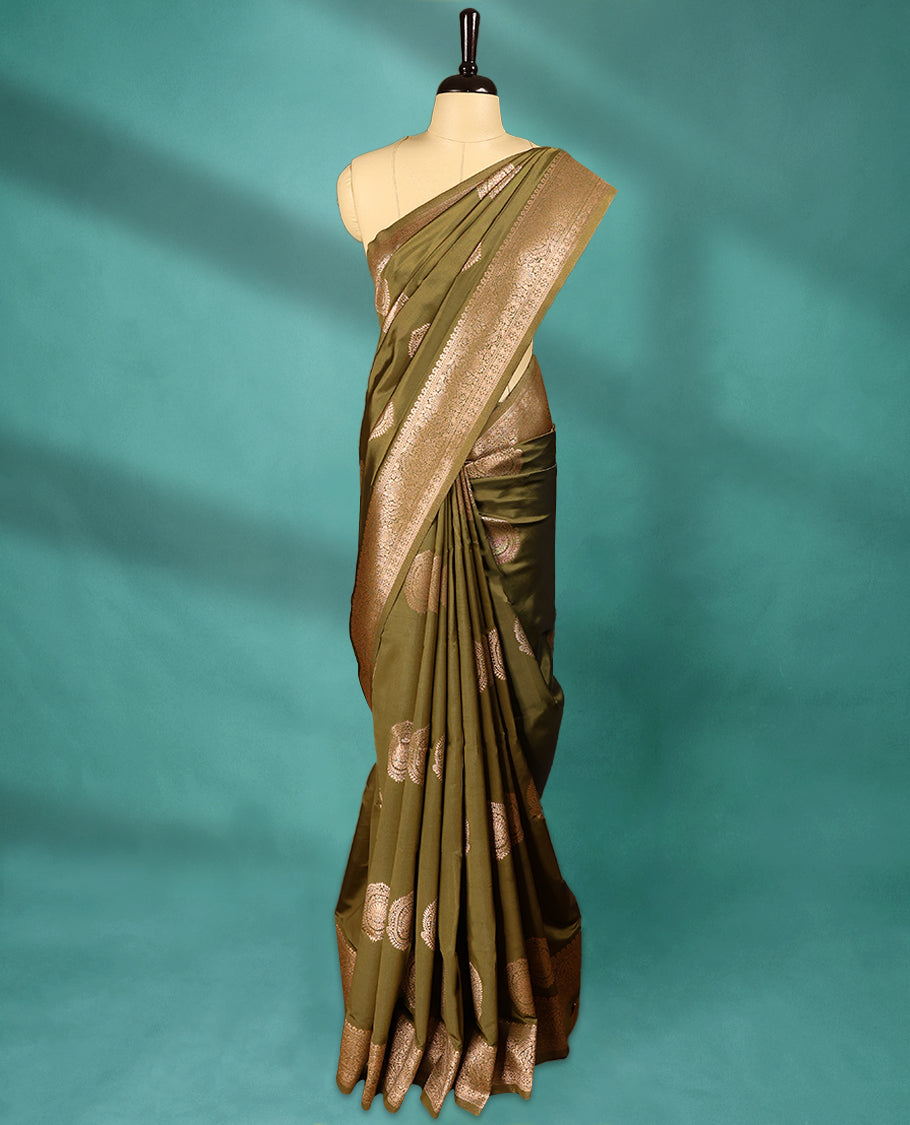 Olive Green coloured semi silk saree featuring a Golden Zari Butta design on the body, paired with a Self coloured border and matching blouse.