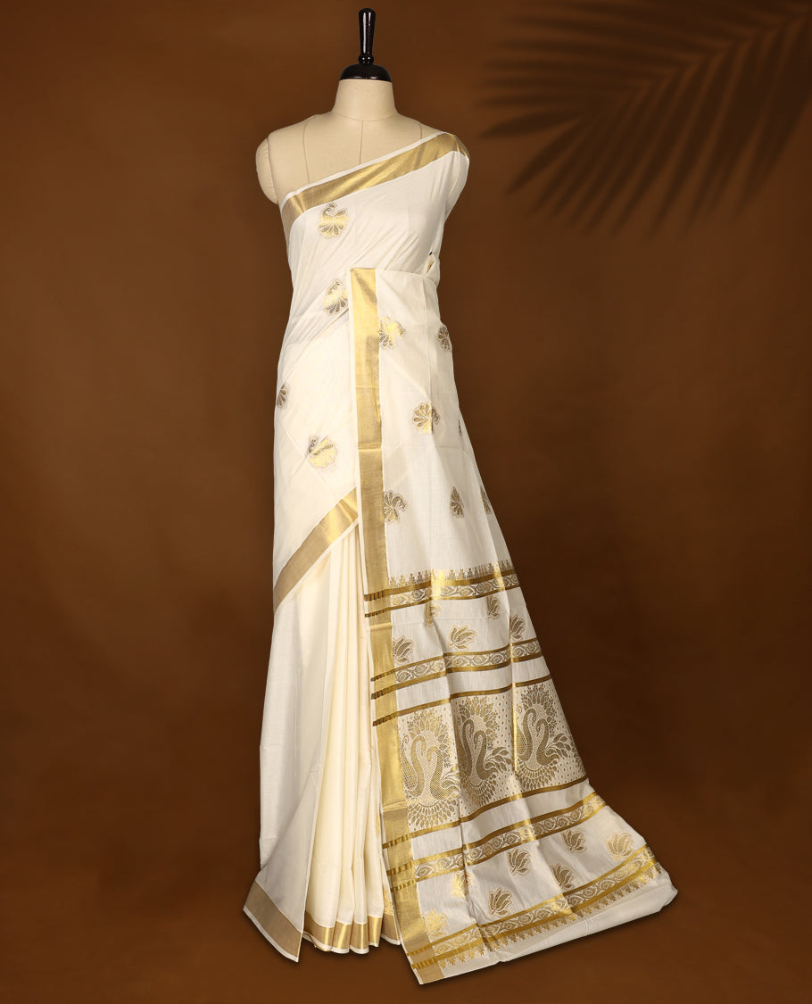 Elegant Off-white colour cotton Kerala saree with golden Peacock motifs on body, Gold zari kazavu border, Rich Pallu paired with matching blouse.