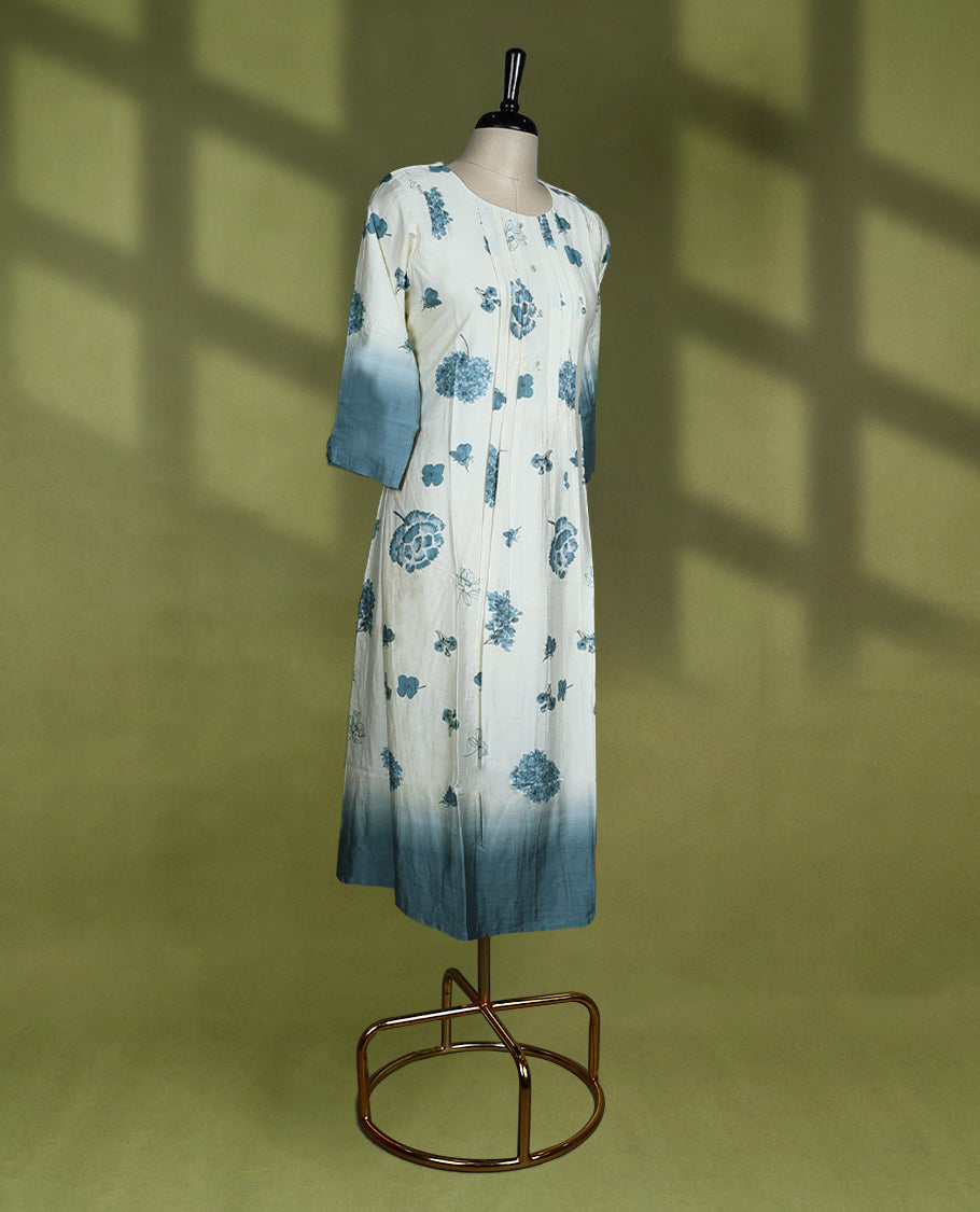 Off-white colour cotton kurti with blue floral prints, ombre dyed three quarter sleeves and hem, featuring a round neckline with a slight slit and front pintuck detailing