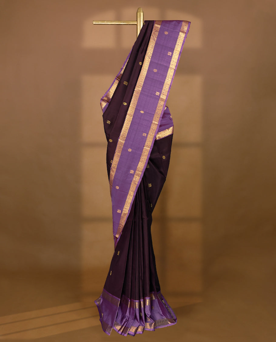 Dark chocolate Colour pure traditional Kancheepuram silk saree adorned with antique zari Chakkram motifs on the body, beautifully complemented by a contrasting traditional border, and paired with a matching blouse.