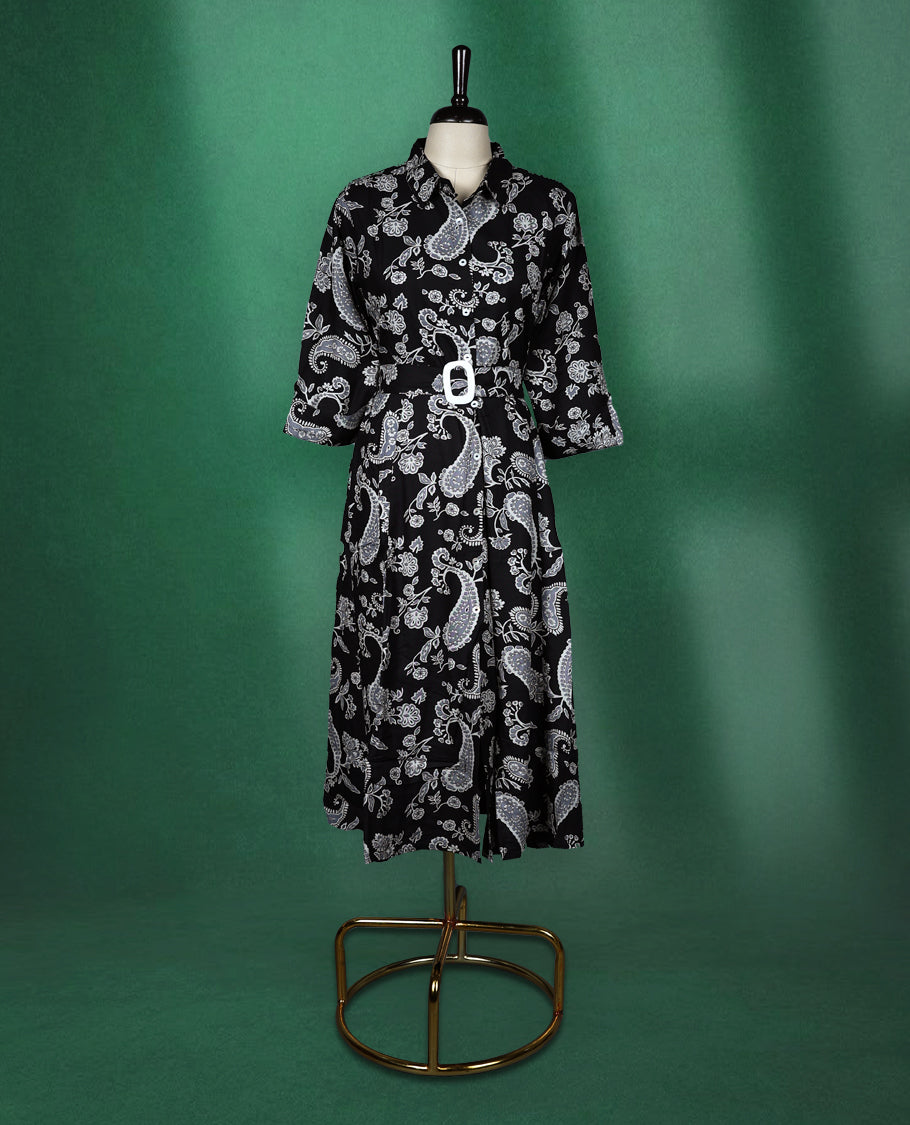 Black shirt style kurti dress featuring elegant white paisley prints, designed with a collared neckline, front buttons, 3/4th sleeves, and a matching fabric belt to accentuate the waist perfect for a smart Indo western look.