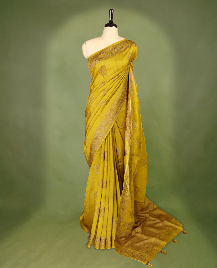 Dark Mustard colour semi Banaras tussar georgette saree embellished with antique zari flower motifs across the body, complemented by a rich Banaras border and paired with a matching blouse.
