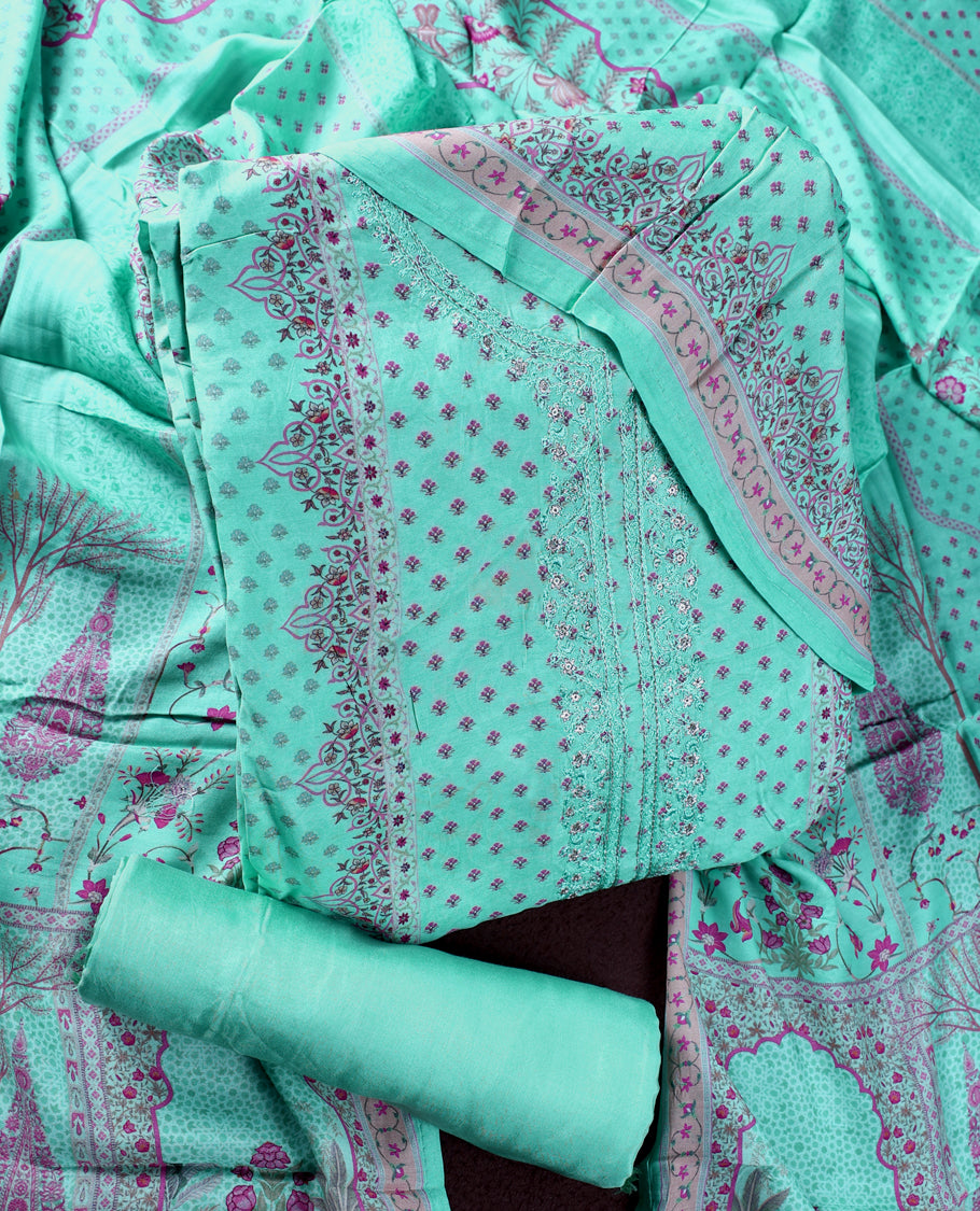 Sea green colour churidhar material featuring delicate peach prints and fine embroidery on the neckline, paired with a matching printed dupatta and plain bottom.