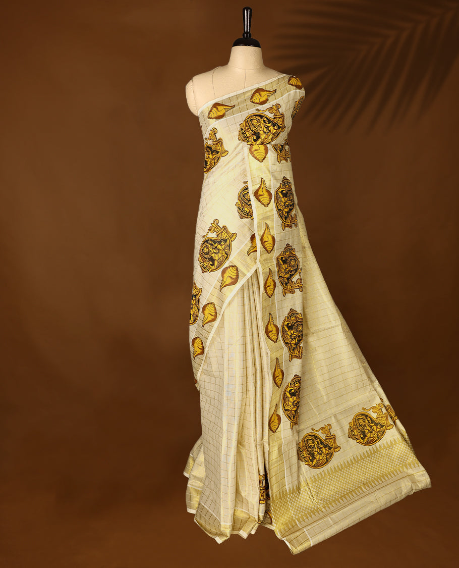 Light Gold colour Tissue Kerala saree featuring Lord Krishna and peacock motifs on the body, golden zari checks, and a beautifully woven border with shell Printed motifs, paired with a matching blouse perfect for festive occasions.