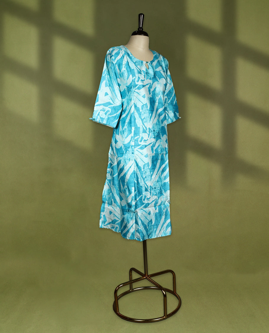 Bright turquoise blue straight cut kurti featuring bold Off white abstract prints, styled with a round neckline and keyhole detail, 3/4th sleeves and side slits, ideal for everyday summer wear.