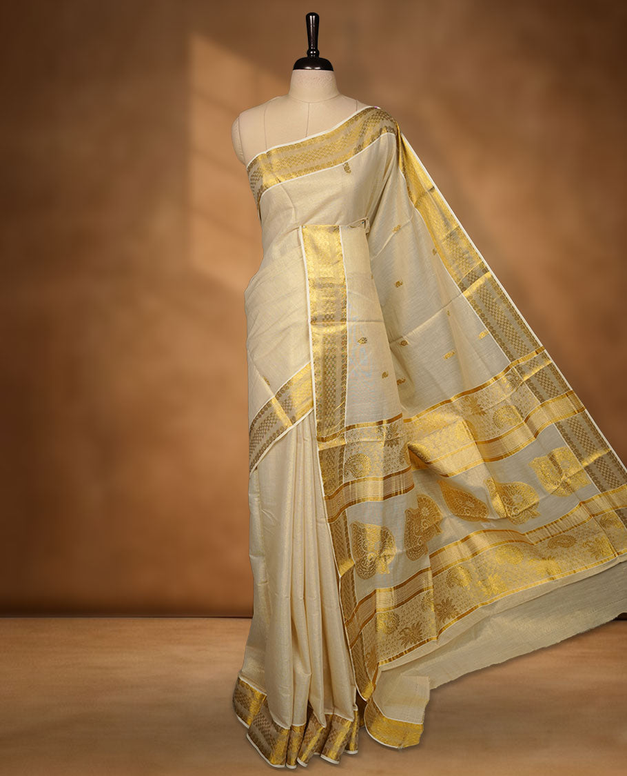 off-white Kerala saree crafted in soft tissue fabric, featuring subtle gold zari buttas across the body, a richly woven traditional pallu with intricate motifs, and a classic kasavu border, paired with a matching blouse.