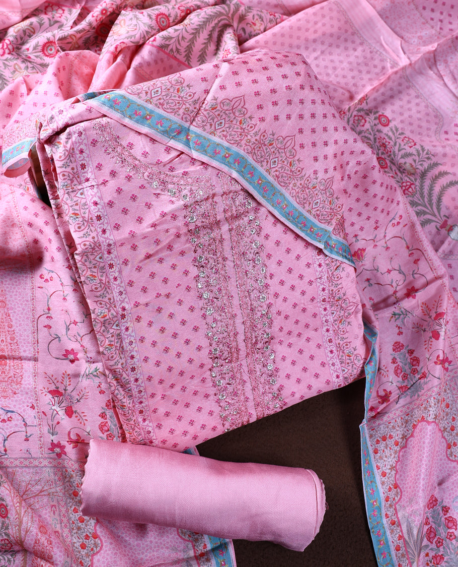 Pink colour churidhar material with intricate embroidery on the neckline and delicate floral prints, paired with a matching printed dupatta and plain bottom.