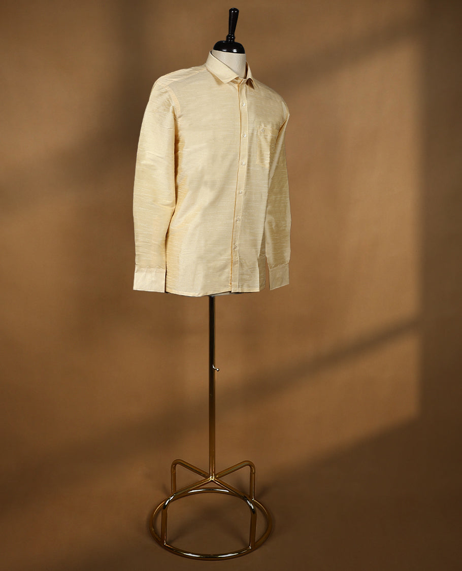 Golden beige DH men’s shirt featuring a glossy silk finish with self textured weave, full sleeves, classic collar, and chest pocket ideal for weddings and traditional functions