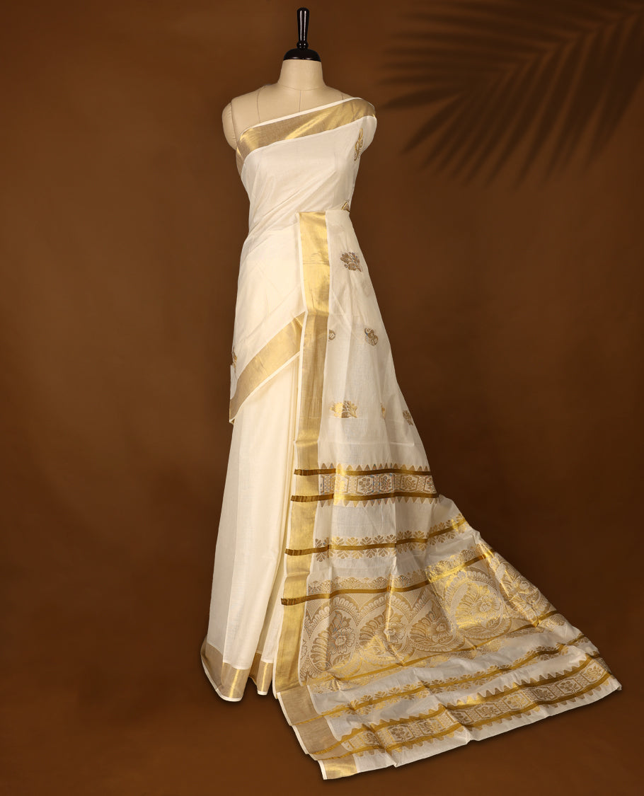 Elegant off white colour cotton Kerala saree featuring Gold zari Traditional motifs on body, traditional golden zari kasavu border & Rich Pallu offering a classic and graceful look, paired with a matching blouse.