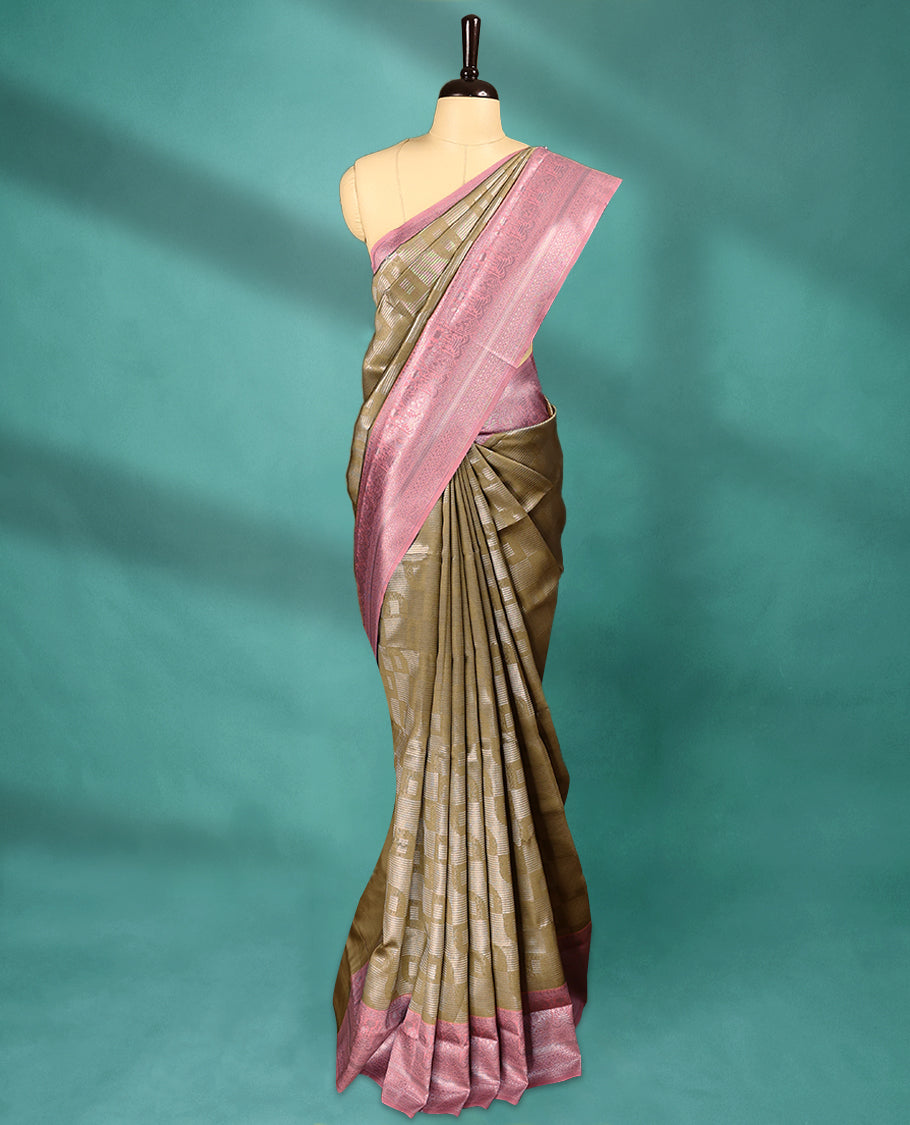 Dark Olive coloured semi silk saree featuring a Silver coloured Zari design on the body, paired with a Onion coloured border and blouse.