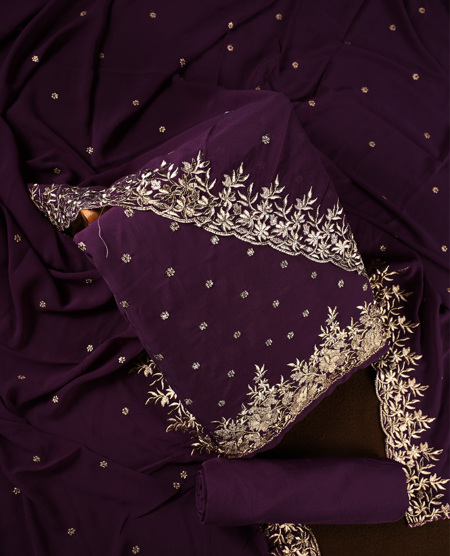 Deep purple churidhar material featuring elegant gold floral embroidery and delicate motifs, paired with a matching embroidered dupatta and plain bottom.