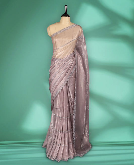 Pastel Pink colour net shimmer fancy saree adorned with subtle horizontal White stone patterns on the body, paired with a delicate stone worked border, with matching blouse