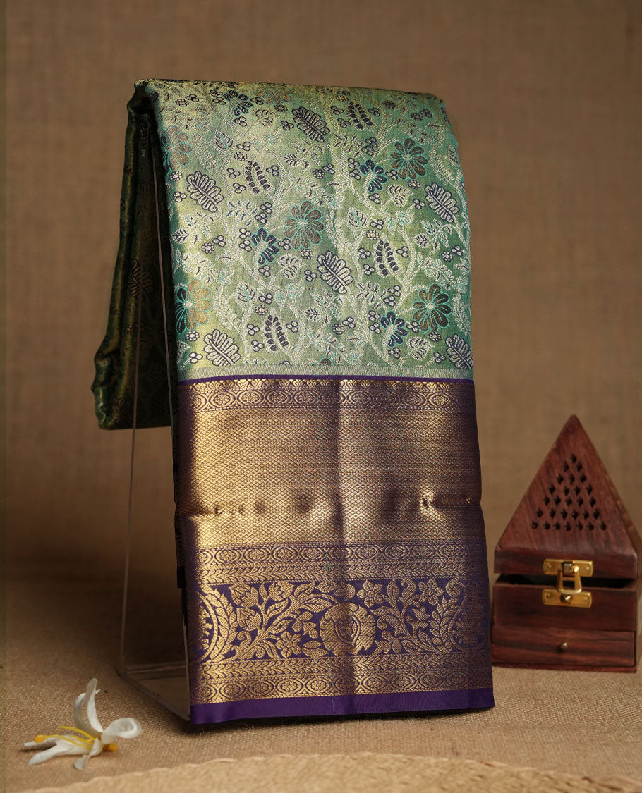 Green colour and Antique gold Zari Tissue Brocade Saree features intricate a coloured floral Motifs on body and rich violet colour with tradiional border & pallu, paired with matching blouse