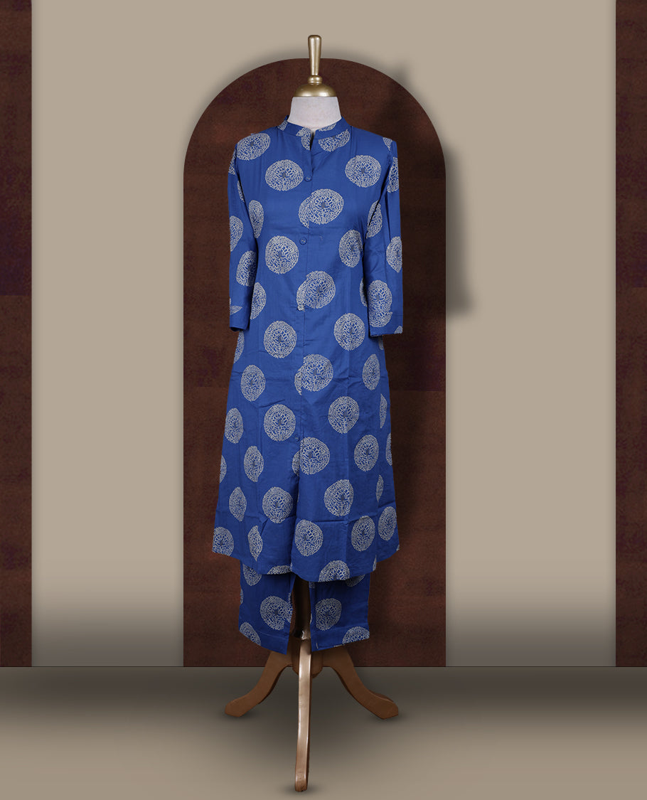 Brick blue colour cotton cord set featuring a straight kurta with a mandarin collar, front buttons, and three quarter sleeves & adorned with white circular block prints and paired with matching palazzo pants.