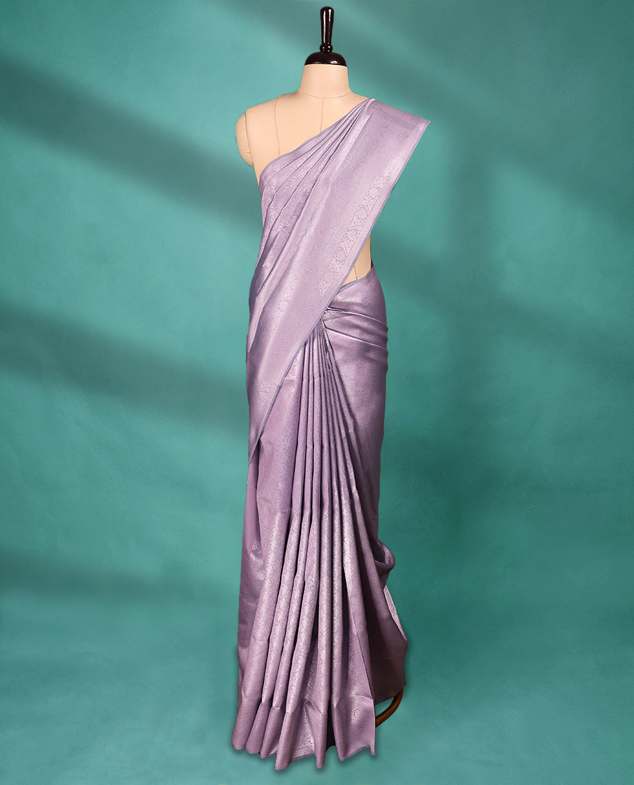 Pastel Purple coloured semi silk saree featuring a Silver coloured Zari Diamond design on the body, paired with a Self coloured border and matching blouse.